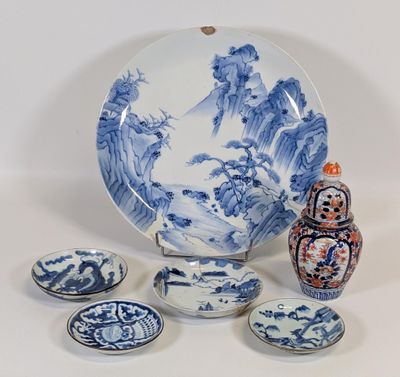 une assiette, des bols et un vase bleus et blancs posés sur une table