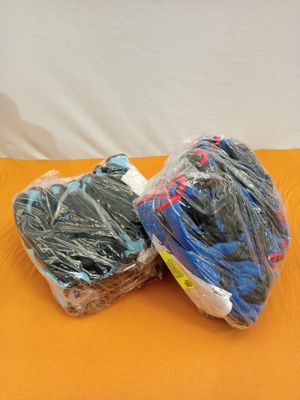 deux pelotes de laine emballées dans du plastique, posées sur une surface orange