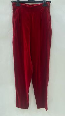 a red pants hanging on a hanger on a white wall