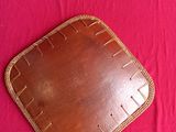 two photos of a brown leather tray on top of a pink cloth