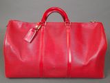 a red louis vuitton bag on a grey background