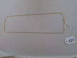 Le collier est en or et porte une étiquette de prix.