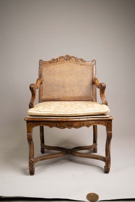 une image représentant une chaise sur laquelle est posé un coussin, avec une pièce de monnaie en arrière-plan