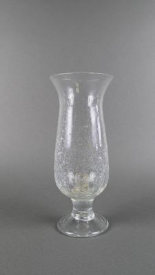 un vase en verre à l'ancienne posé sur une table