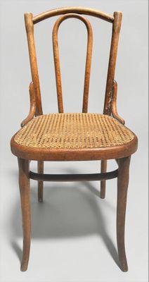 une vieille chaise en bois avec un dossier et une assise en rotin