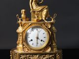 une horloge en or posée sur une table noire