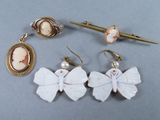 trois paires de boucles d'oreilles et une broche posées sur une table