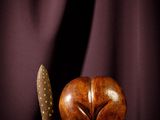 un objet en bois surmonté d'un couteau, posé sur une table