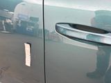 a reflection of a man in a mirror on the door of a car