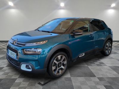 a blue citrole parked in a room with a checkered floor