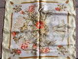 un foulard carré orné d'un motif représentant un oiseau et des fleurs