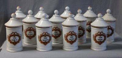 several white and brown canisters are lined up on a table