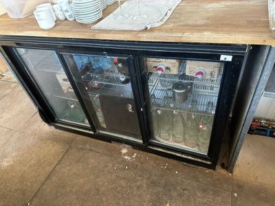 a counter with a glass door that has plates and cups on it