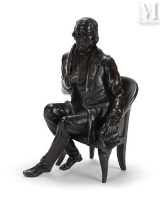 statue représentant un homme assis sur une chaise, les jambes croisées