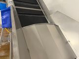 a conveyor belt with a blue bag on it
