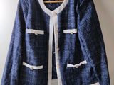 blue and white jacket hanging on a hanger on a wall