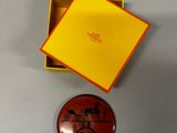 une boîte orange avec un couvercle jaune et un petit bouton rouge sur lequel figure un personnage de dessin animé