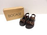 brown leather sandals with buckles and a box on a white surface