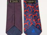 two ties with red and blue designs on them on a white surface