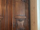 a large wooden armoire in the corner of a room