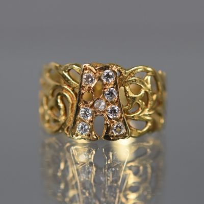 un gros plan d'une bague en or sertie de diamants sur une surface réfléchissante