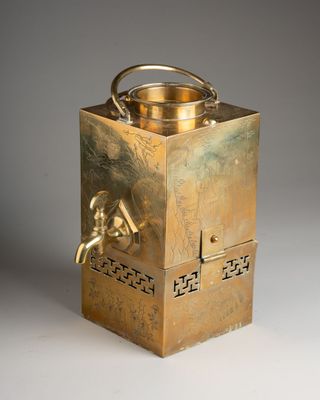 a brass tea kettle that is sitting on a table