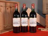 three bottles of wine sitting on a table next to a wooden box
