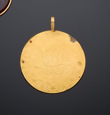 un gros plan d'une médaille d'or sur laquelle figure un médaillon