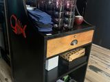 a black and wooden bar cart with glasses on it