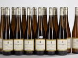 six bouteilles de vin sont alignées sur une surface blanche