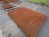 an image of a metal grate laying on the ground in front of a building