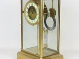 a gold clock with a glass case on top of it