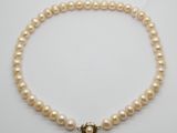 un collier de perles à un rang avec un fermoir en or