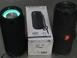 a box with a bluetooth speaker sitting next to a black speaker