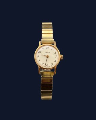 un gros plan d'une montre-bracelet en or sur fond bleu