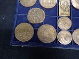 a box of gold coins with different designs on them
