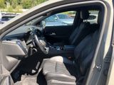 the interior of a car with the door open and the driver ' s seat down