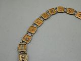 an image of a gold bracelet with the word love spelled on it