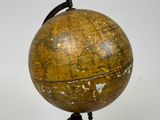 an old globe on a tripod stand with a white background