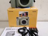 a camera sitting on top of a box next to a cord