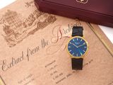 une montre posée sur une feuille de papier à côté d'une boîte