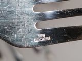 a close up of a metal fork with a piece of metal on it