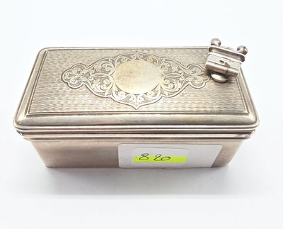 une vieille boîte en argent posée sur une surface blanche