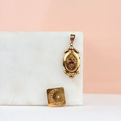 un fermoir en or orné d'un petit diamant et d'un petit pendentif carré
