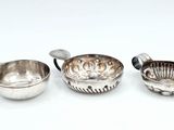 trois bols et cuillères en métal argenté posés sur un fond blanc