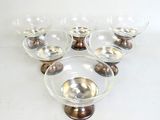 six bols en verre transparent à bord doré, posés sur un socle en bois