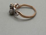 a gold ring with a flower on it on a table