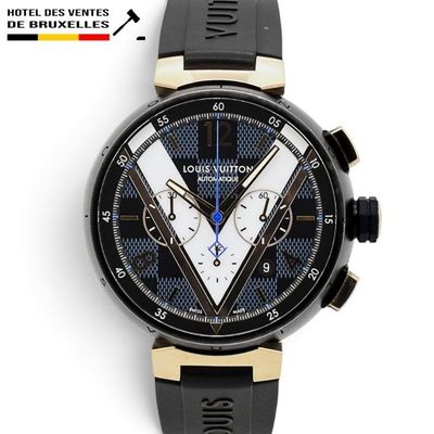 La montre est noire et dorée, avec un cadran bleu et blanc.