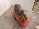 a small air compressor sitting on the floor in a room