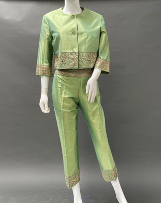 a mannequin wearing a green suit with gold trimmings